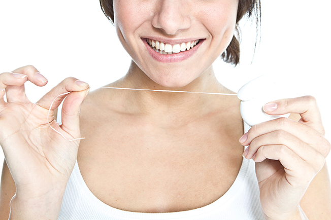 Woman holding floss to promote dental hygiene and preventative dental care